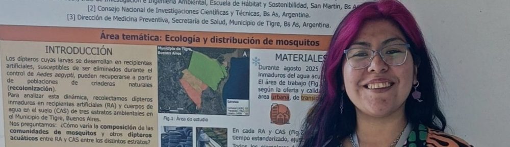 Imagen de cabecera para el perfil de Melisa Elin Gutierrez Cornejo, en el que posa delante de un poster suyo en una exposición.